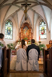 Ein Brautpaar sitzt vor einem Altar